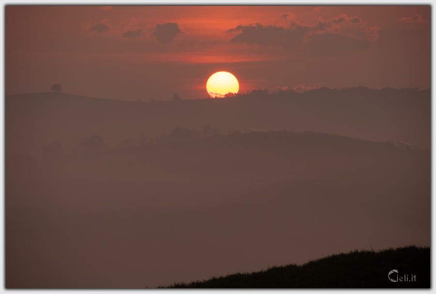 Mattina presto con nebbia e sole che spunta dalle colline Mattina presto con nebbia e sole che spunta dalle colline